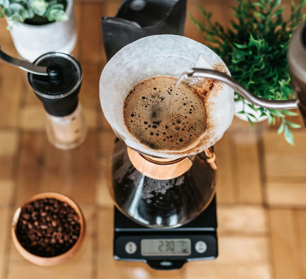 Coffee pour over setup on a scale with a grinder and extra beans